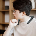 A person wearing a sleek, matte black wireless neckband speaker for portable, hands-free surround sound.