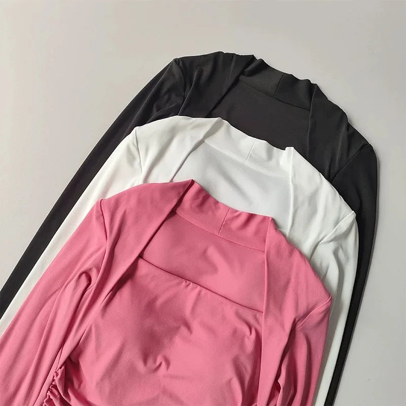 Three long-sleeved, square-neck tops stacked in pink, white, and black, featuring fitted silhouettes.