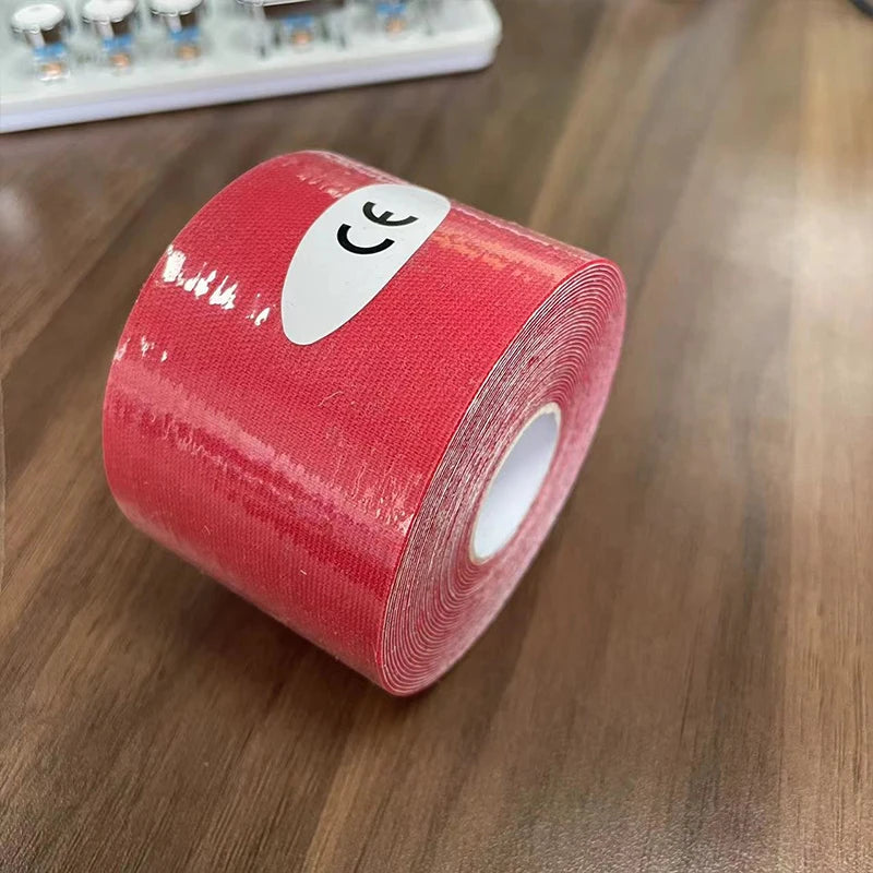 A roll of bright red kinesiology sports tape with a white CE sticker on a wooden surface.