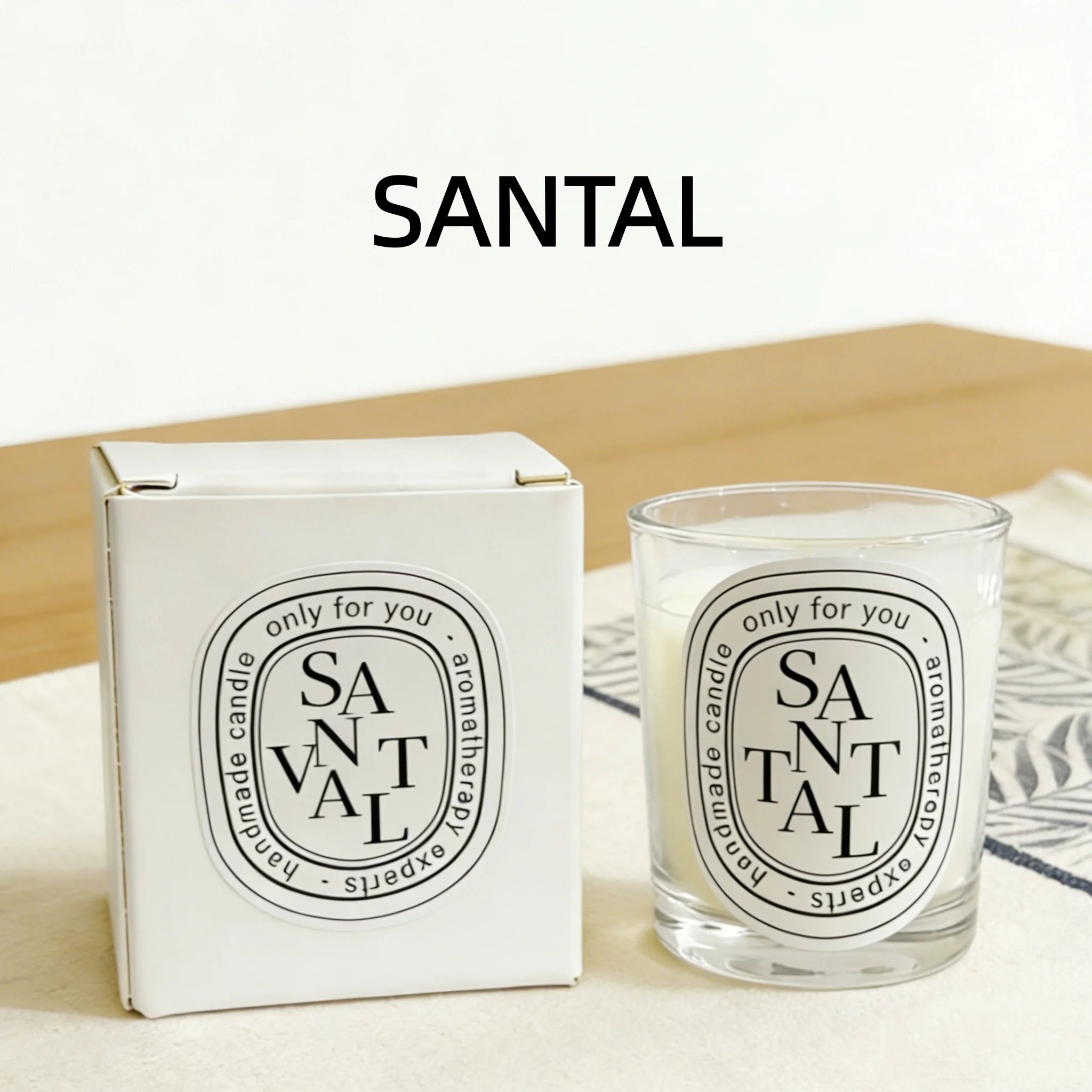 Santal scented candle in a clear glass jar with matching white box, featuring a minimalist black and white label.