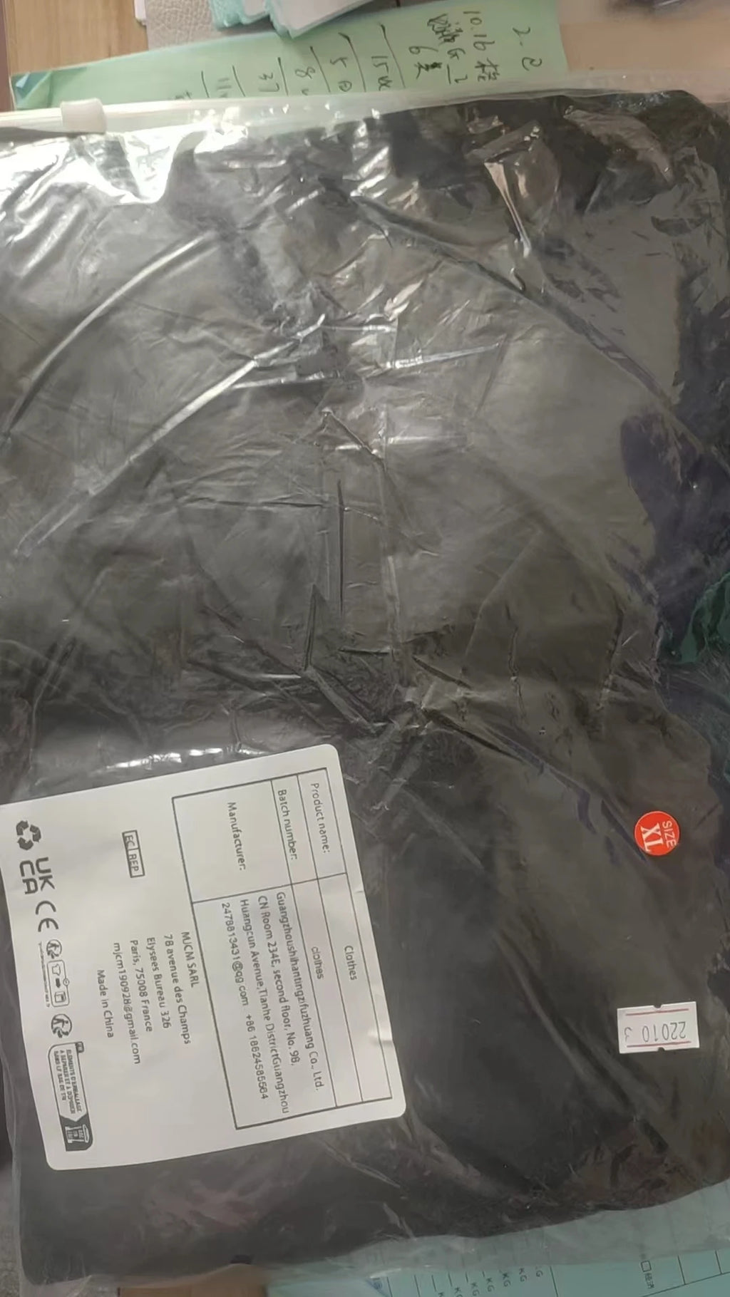 Black garment in size XL, sealed in protective plastic packaging with product label.