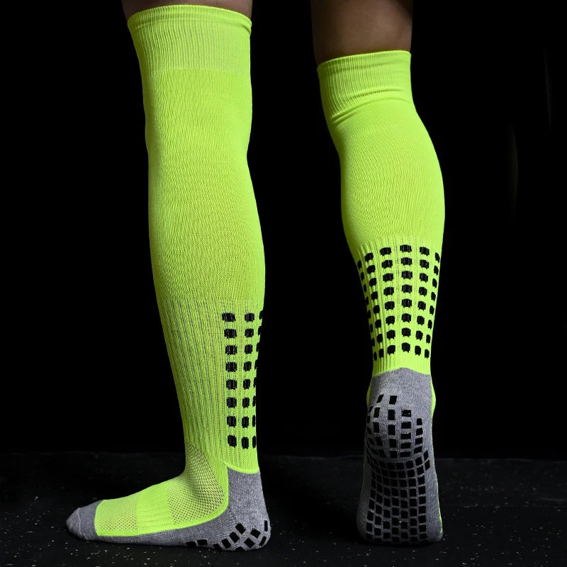 Neon yellow knee-high sports socks with grey heels/toes and black anti-slip grip pads on the soles.