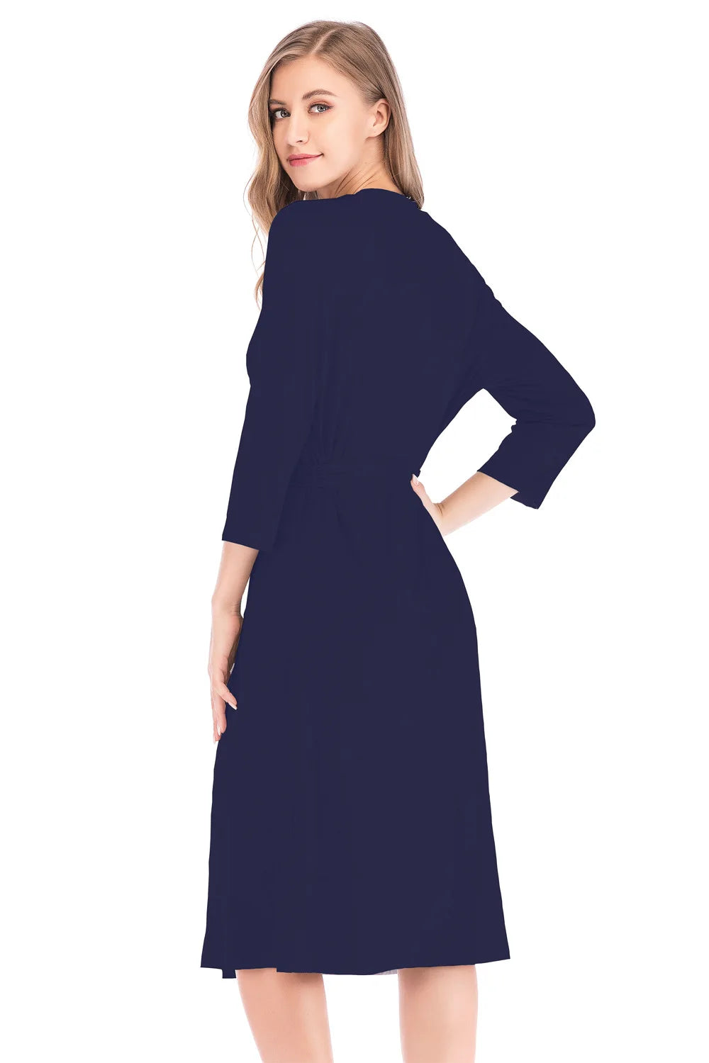 Woman wearing a navy blue knee-length wrap dress with three-quarter sleeves, shown from the side and back.
