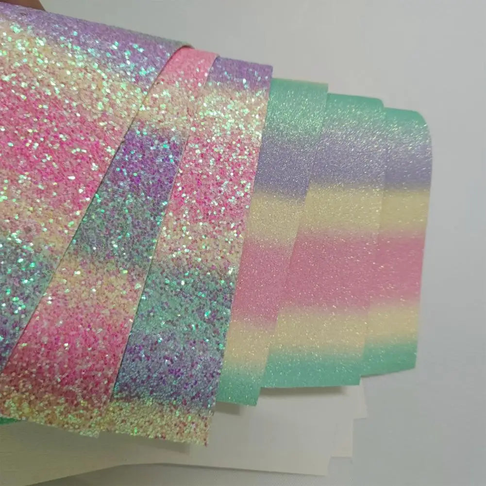 Sheets of iridescent glitter faux leather featuring a pastel rainbow gradient of pink, yellow, and mint green.