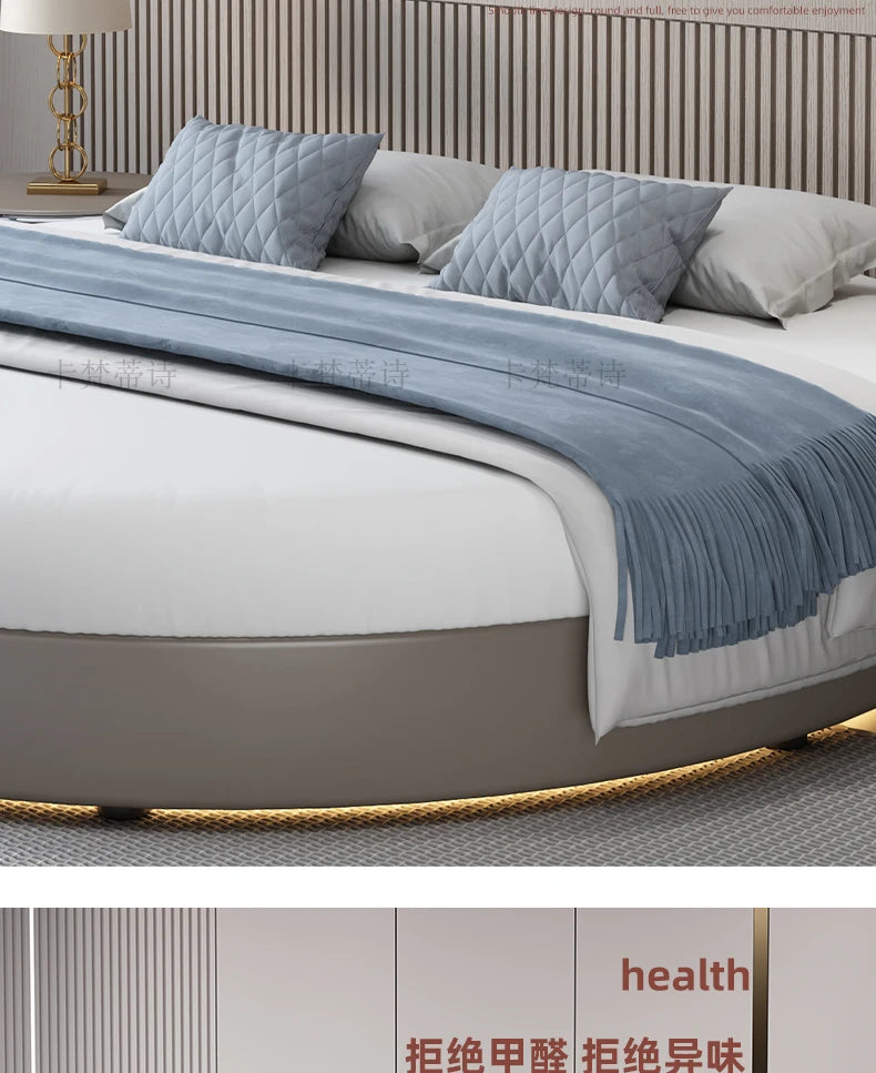Modern minimalist circular grey bed frame with a panelled headboard and integrated base lighting.