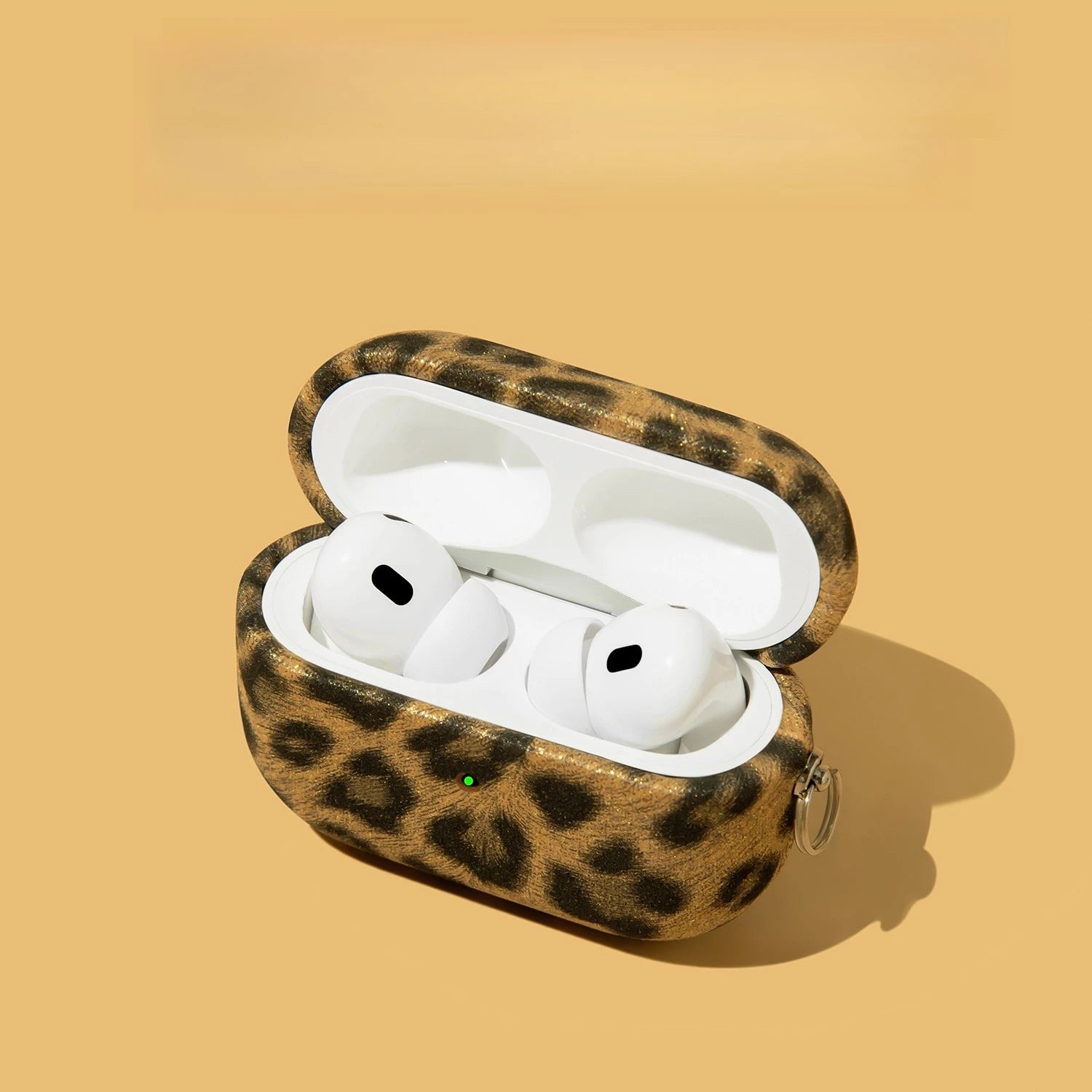 Leopard print AirPods Pro case in a textured, gold-flecked finish with a side attachment ring.