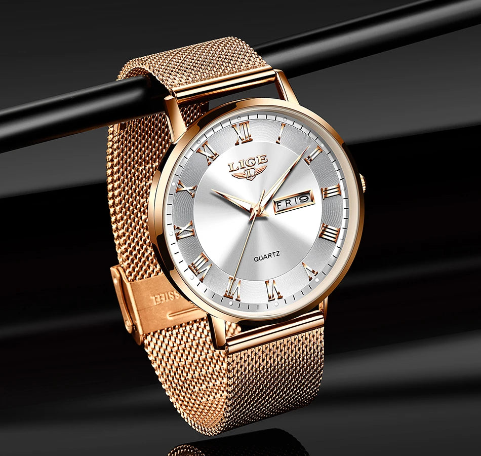 Elegant rose gold women's watch with a mesh strap, silver face, Roman numerals, and a day-date display.