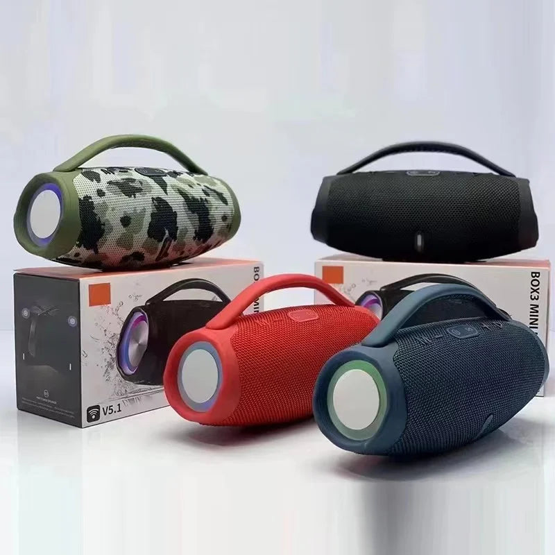 Four portable, cylindrical Bluetooth speakers in camo, black, red, and blue, featuring carry handles and RGB side lights.