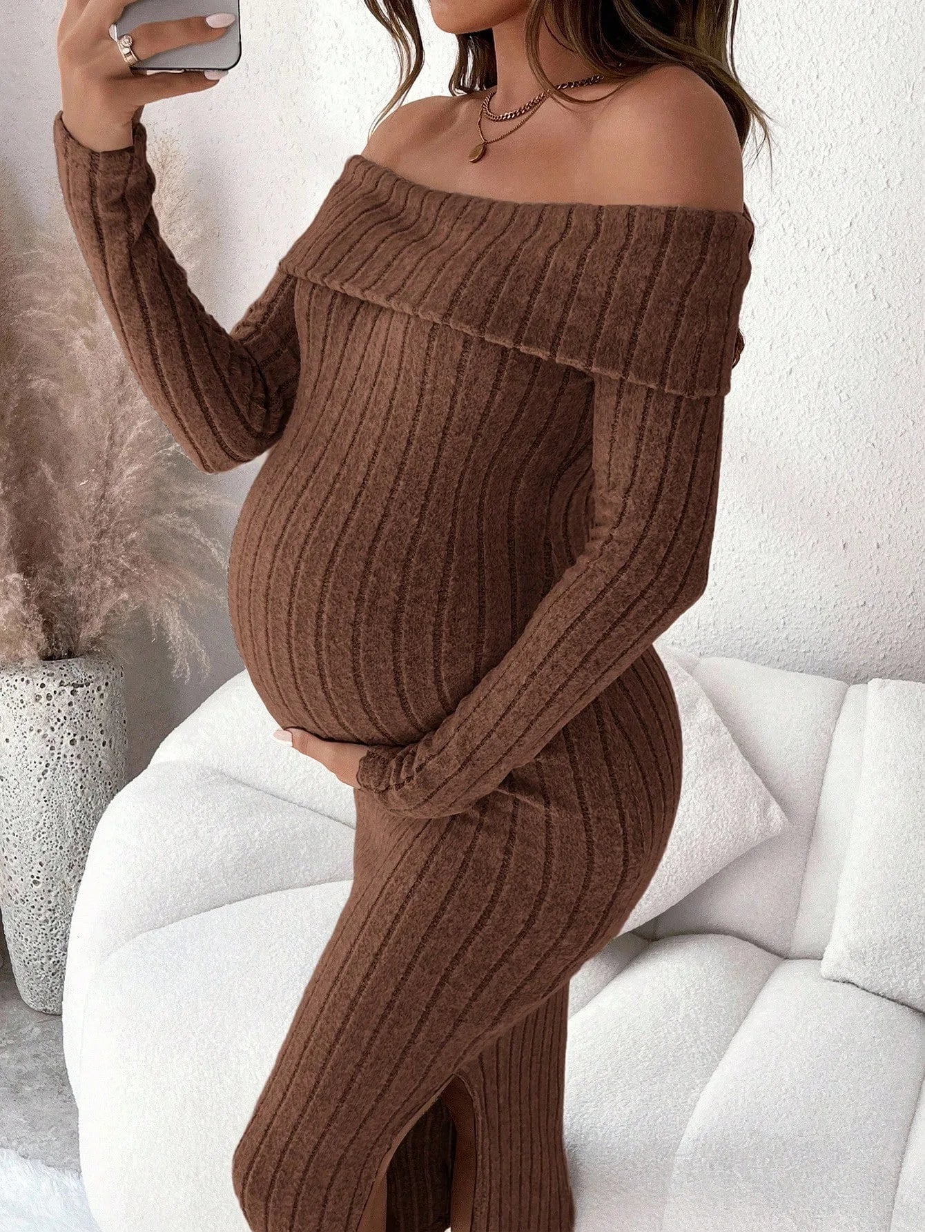 Brown ribbed maternity midi dress with off-the-shoulder neckline, long sleeves, and a side slit.
