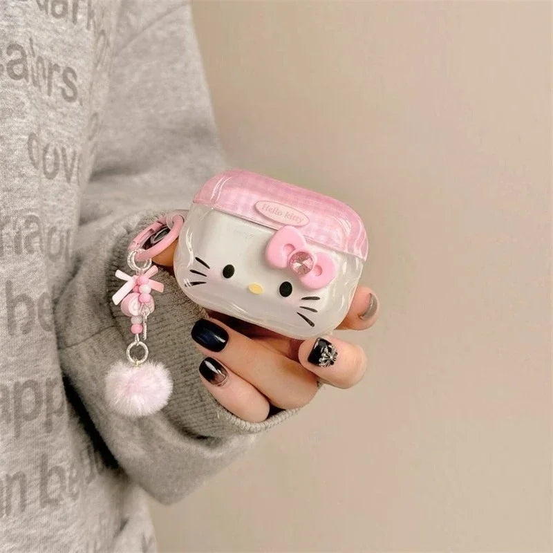 Clear AirPods Pro case with pink Hello Kitty lid design, bow charm, and fluffy pom-pom keyring.
