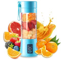 Portable light blue smoothie blender filled with chopped fruit, surrounded by various fresh citrus and berries.
