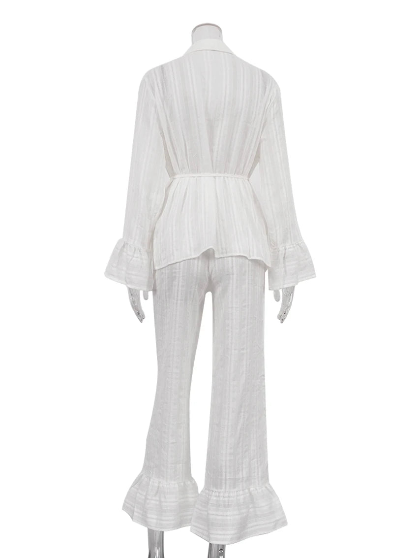 White striped two-piece set with a belted shirt featuring flared sleeves and matching wide-leg trousers with ruffles.