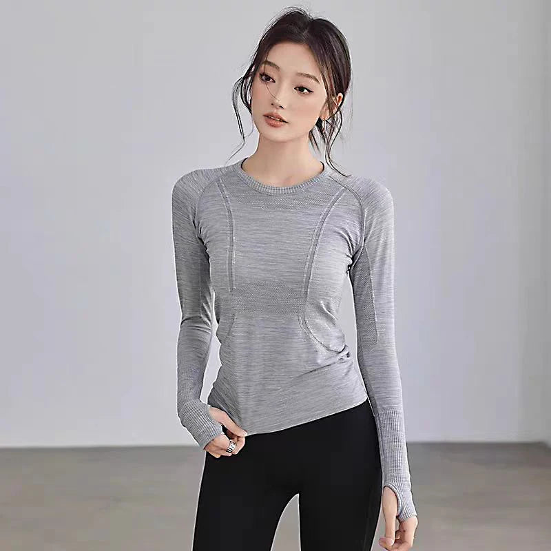 Grey long-sleeve gym top with seamless construction, textured detailing, and integrated thumbholes.