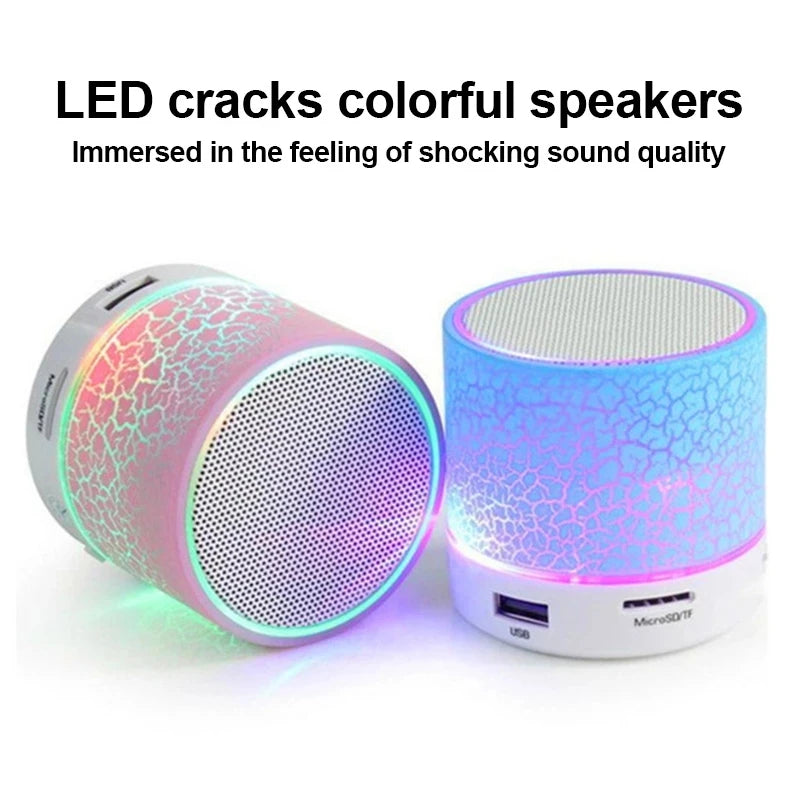 Two mini portable wireless speakers with colourful crackle-effect LED light designs and silver metal speaker grilles.