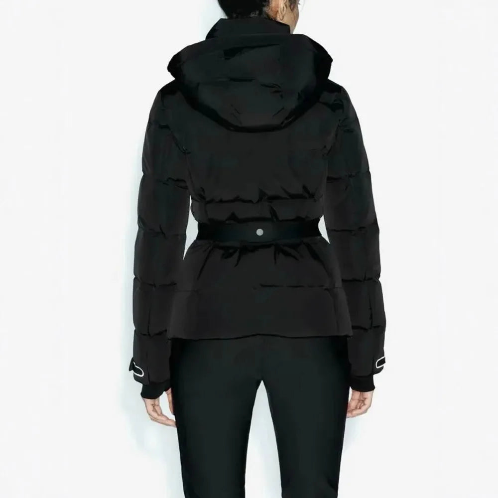 Back view of a black, hooded, quilted puffer jacket with a fitted waist belt, worn over black trousers.