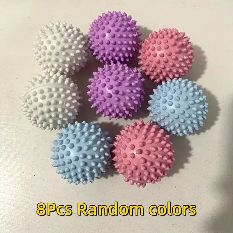 Eight colourful, spiky massage balls in various pastel shades arranged on a white surface.
