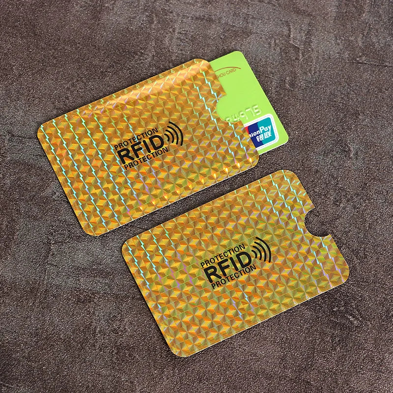 Two gold holographic RFID-blocking credit card sleeves with protective casing, one shown with a card inside.