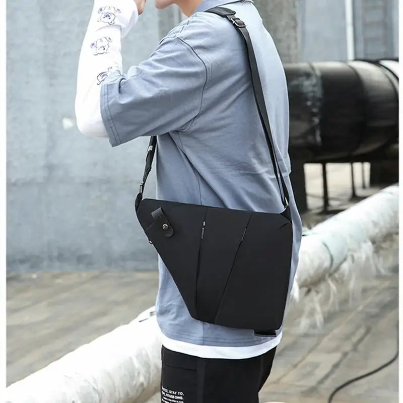 A sleek, black waterproof crossbody chest bag with an anti-theft design, worn over the shoulder by a man.