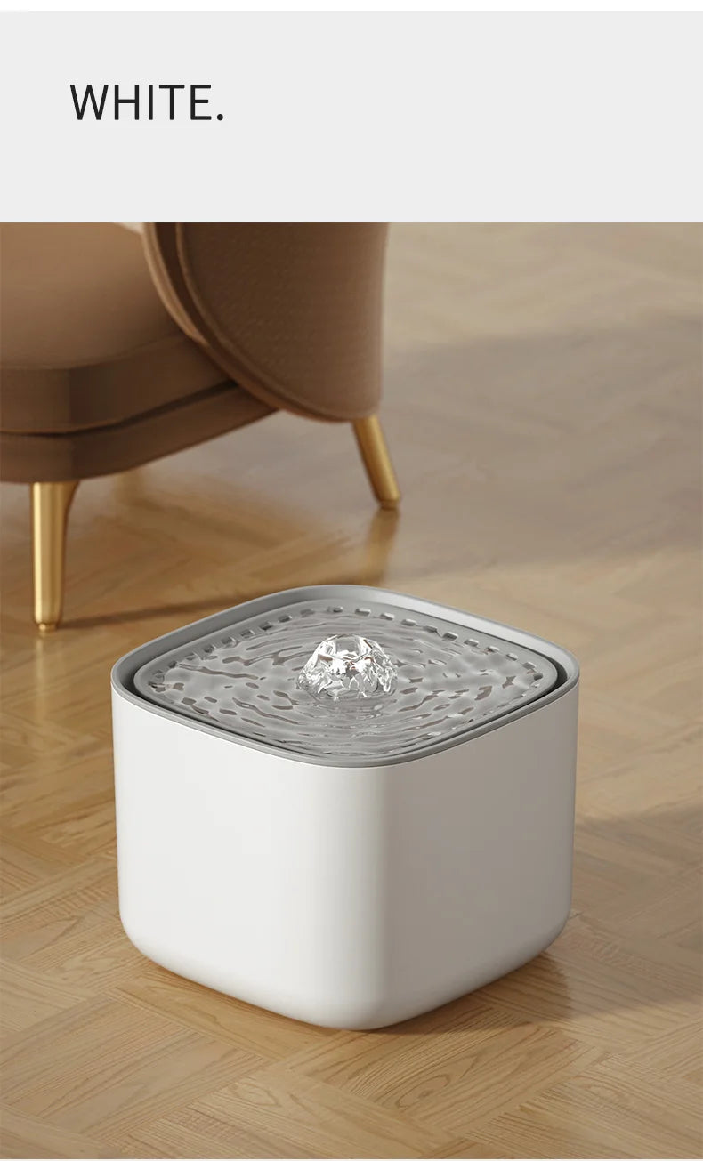 A modern, square white pet water fountain with a grey top tray and a small, crystal-like water bubbler.