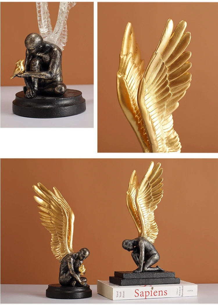 Decorative sculpture of a kneeling figure with large gold wings, featuring a distressed grey finish and a small bird.