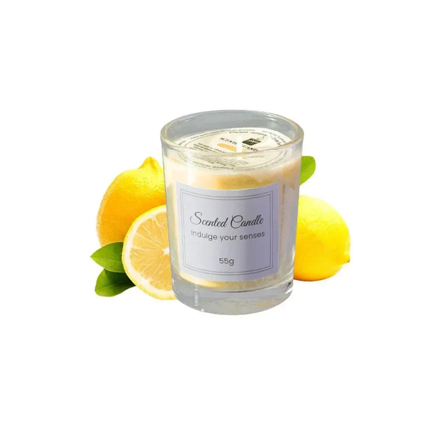 Yellow lemon-scented candle in a glass votive, 55g, surrounded by fresh lemons and leaves.
