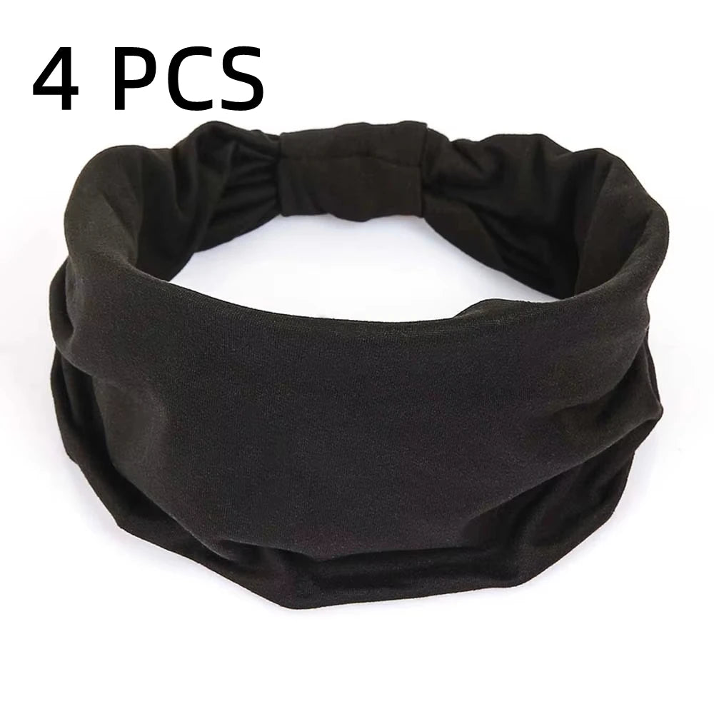 A pack of four plain, black stretchy fabric headbands with a wide, gathered design.