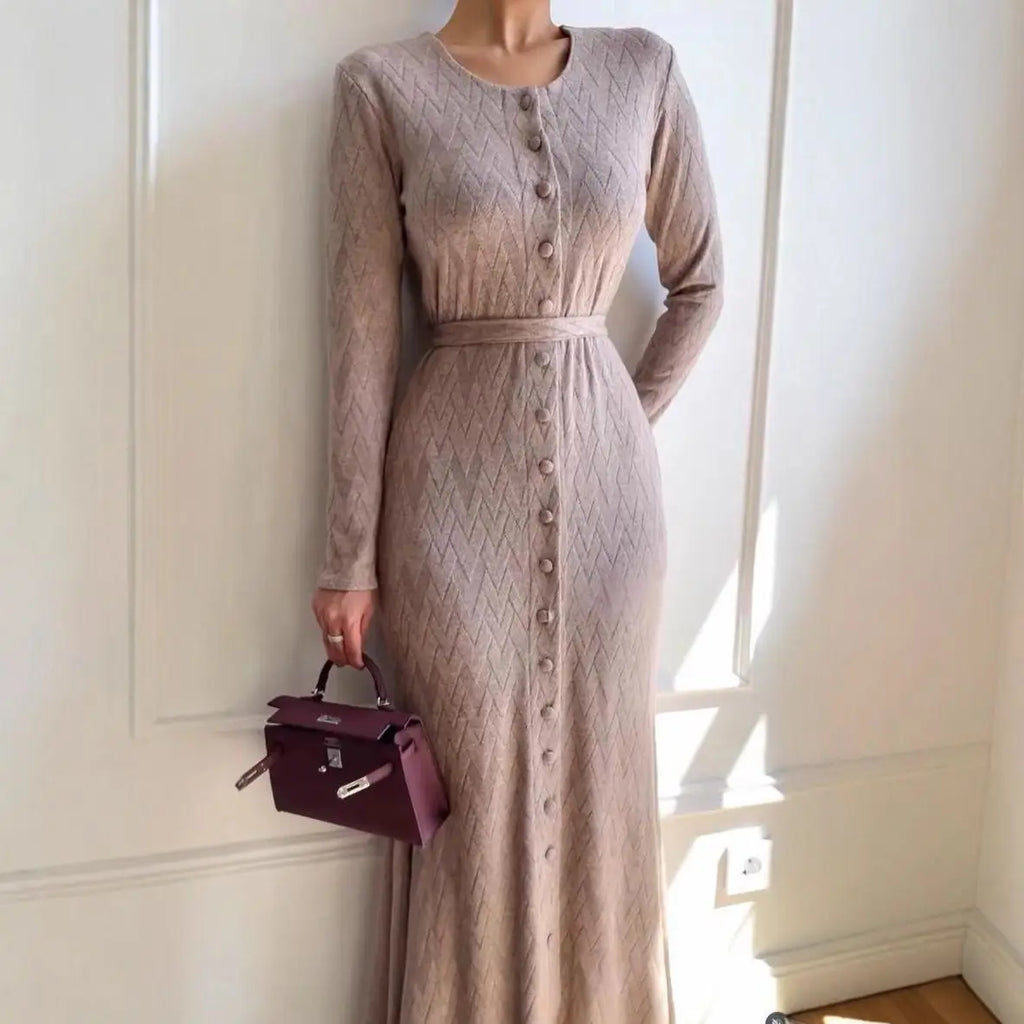 Beige, long-sleeve knit maxi dress with a button-down front, textured chevron pattern, and a waist-defining belt.