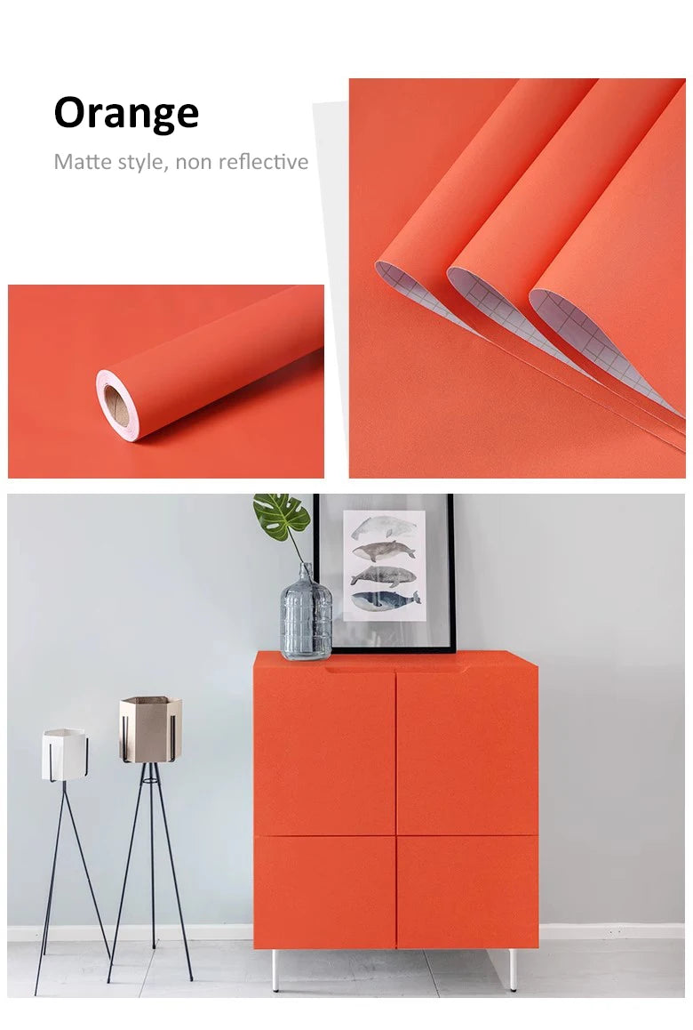 Bright orange self-adhesive wallpaper roll with a smooth, non-reflective matte finish, shown on a modern cabinet.