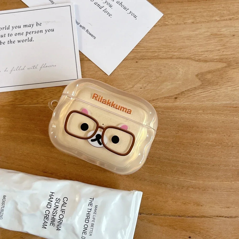 Clear silicone AirPods Pro case featuring a cute Rilakkuma bear design with glasses, on a wooden surface.