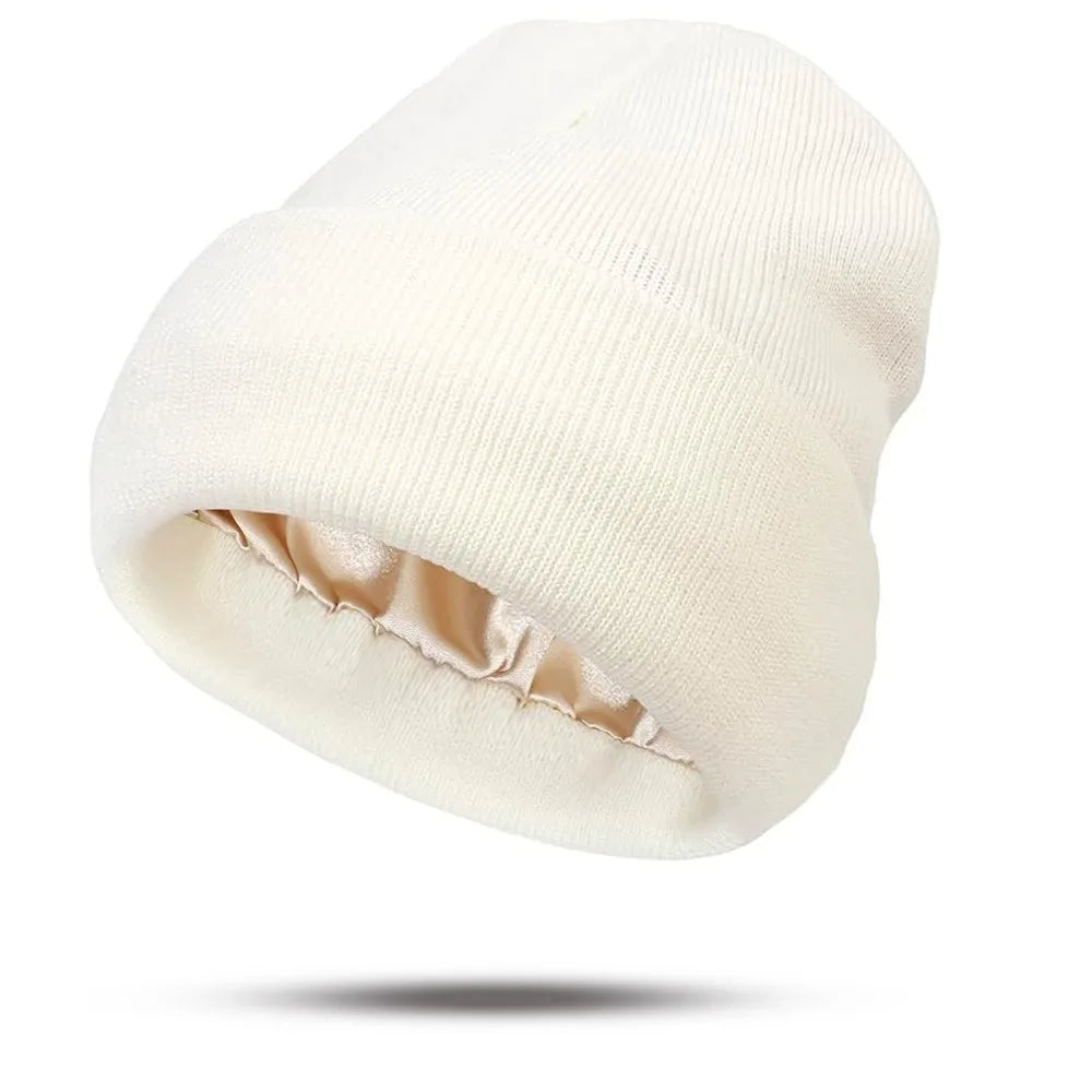 Cream-coloured knitted beanie with a smooth champagne-gold satin lining.