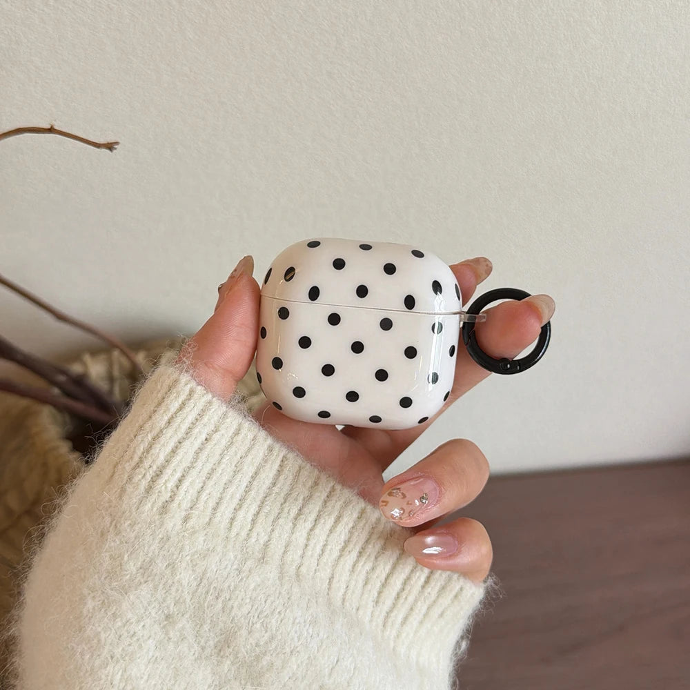 White AirPods case with black polka dots, glossy finish, and attached black keyring. Compatible with AirPods.