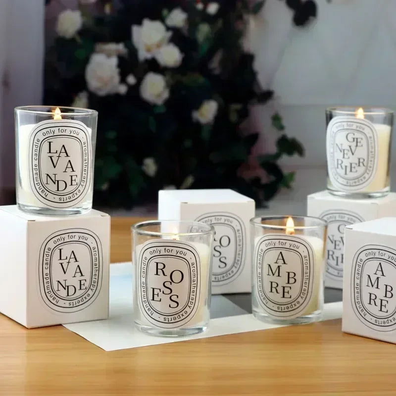 Set of four scented candles in glass jars with black and white minimalist labels, each with matching gift boxes.