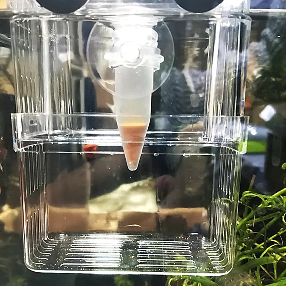 Clear plastic aquarium fish feeder with suction cup attachment and a conical container filled with orange fish food.