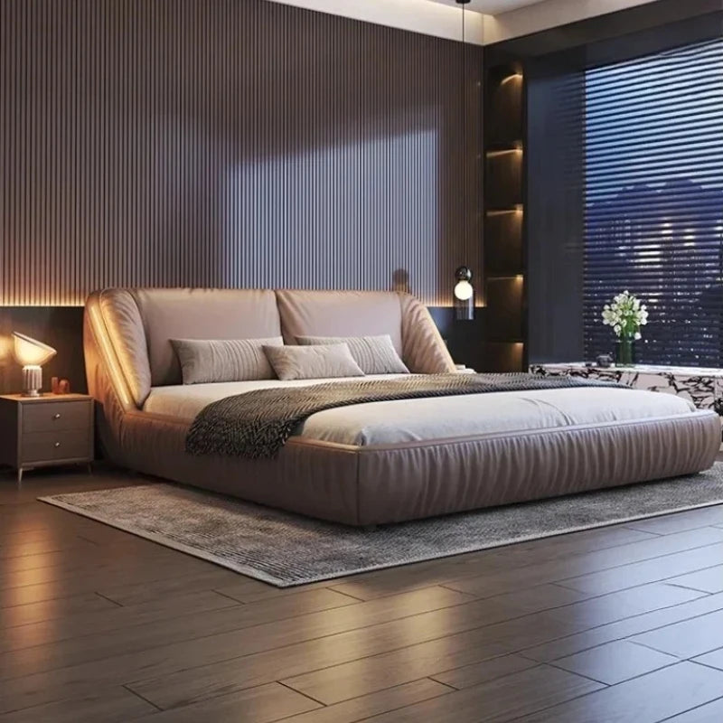 Modern king-size upholstered bed frame in a taupe leather finish with curved, plush headboard and low-profile design.