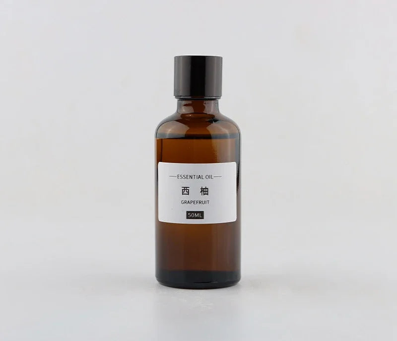50ml amber glass bottle of grapefruit essential oil with a black screw cap and minimalist white label.