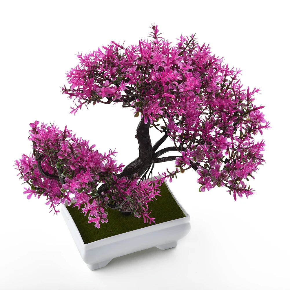 Artificial bonsai tree with vibrant magenta leaves, dark brown trunk, and a white square pot on a white background.