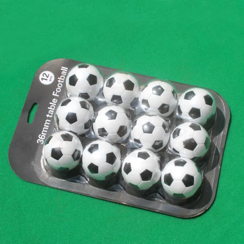 Pack of 12 miniature 36mm black and white table football balls in plastic blister packaging.