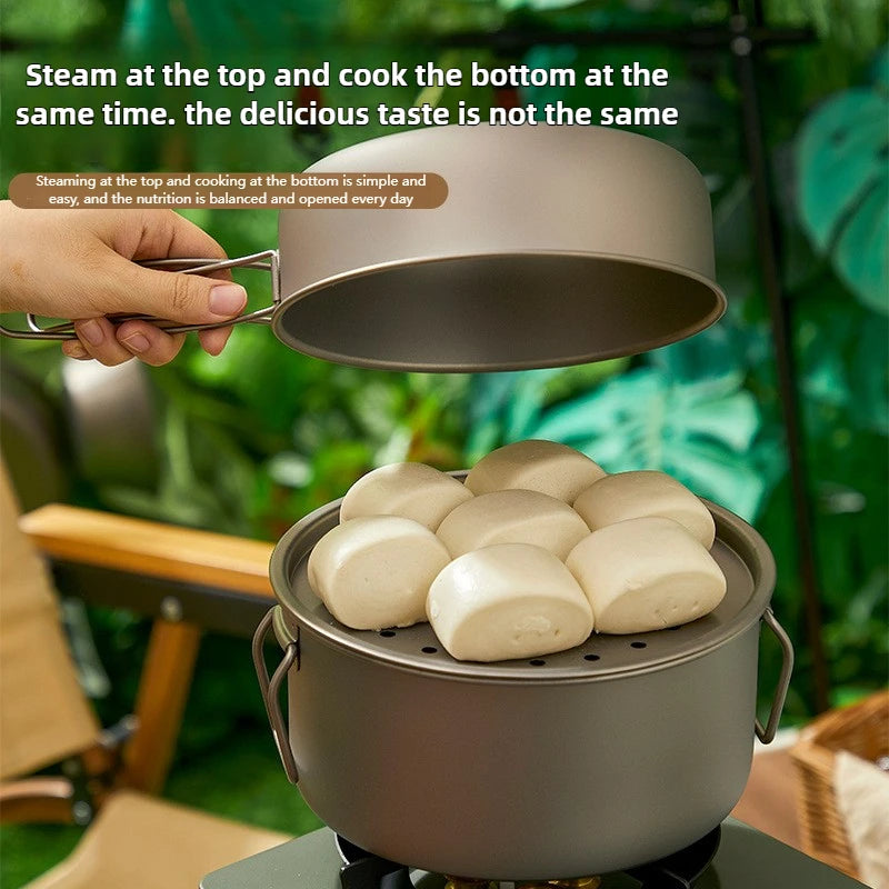 A hand holding the lid of a two-tier titanium camping pot, revealing steamed buns inside.