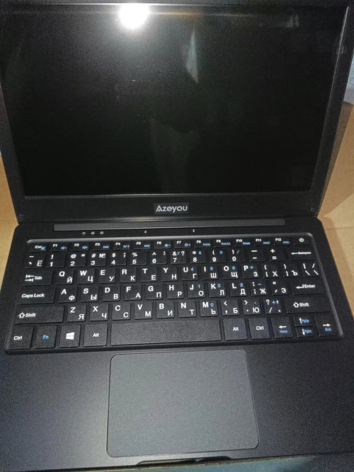 Slim black 11.6-inch laptop featuring a compact design, UK QWERTY keyboard with Cyrillic characters, and a touchpad.