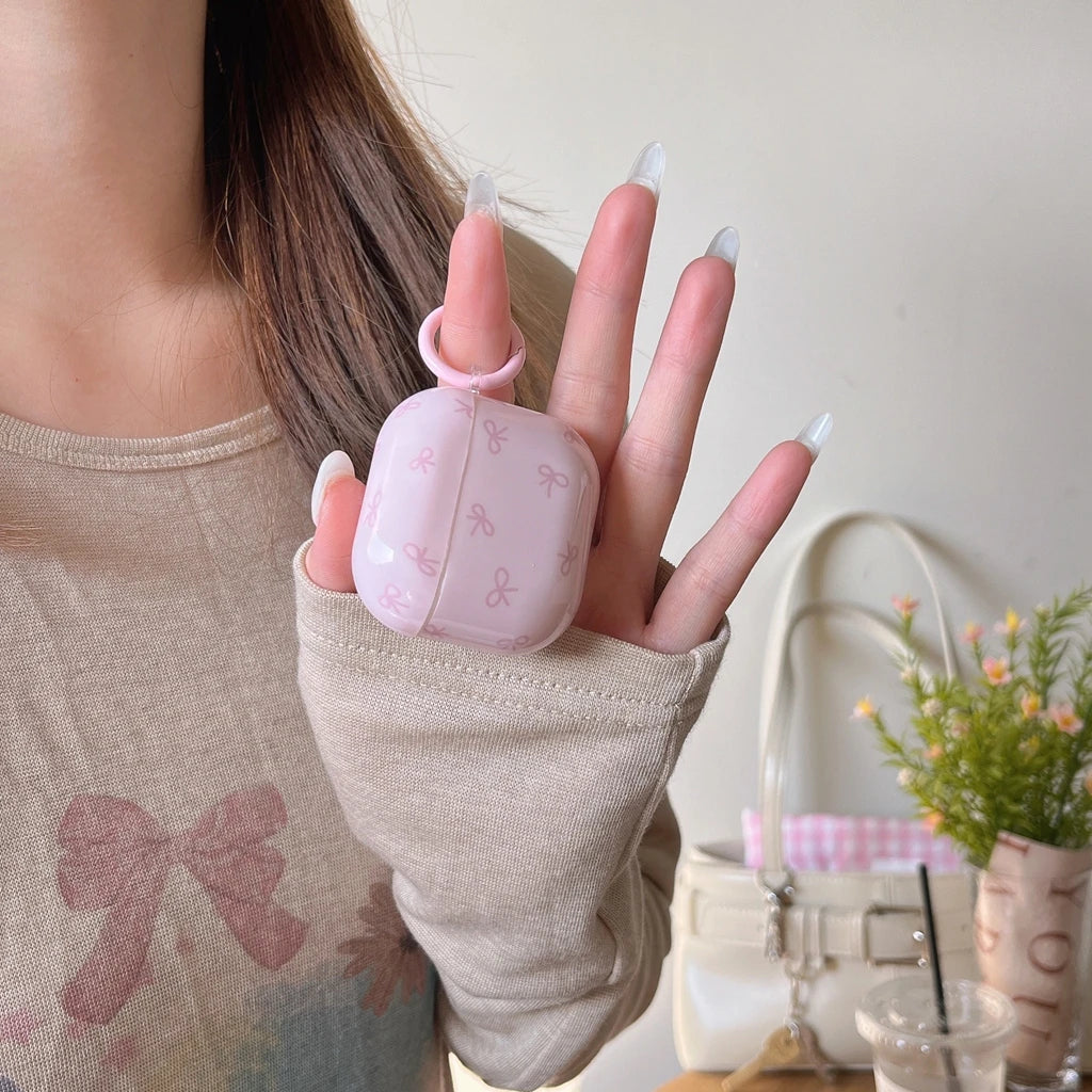 Pink bow-print AirPods case with matching finger ring. Glossy protective cover for AirPods.