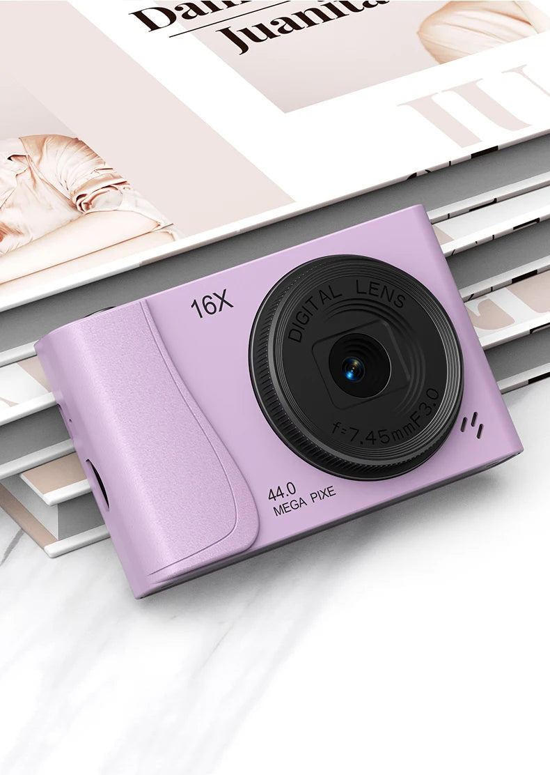 Light purple compact digital camera with a black lens, 16x zoom, and 44-megapixel resolution.