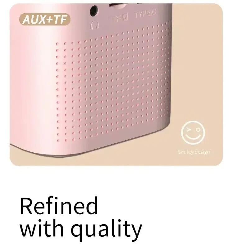 Pastel pink wireless speaker with a perforated grille, AUX and TF card ports, and a cute smiley face detail.