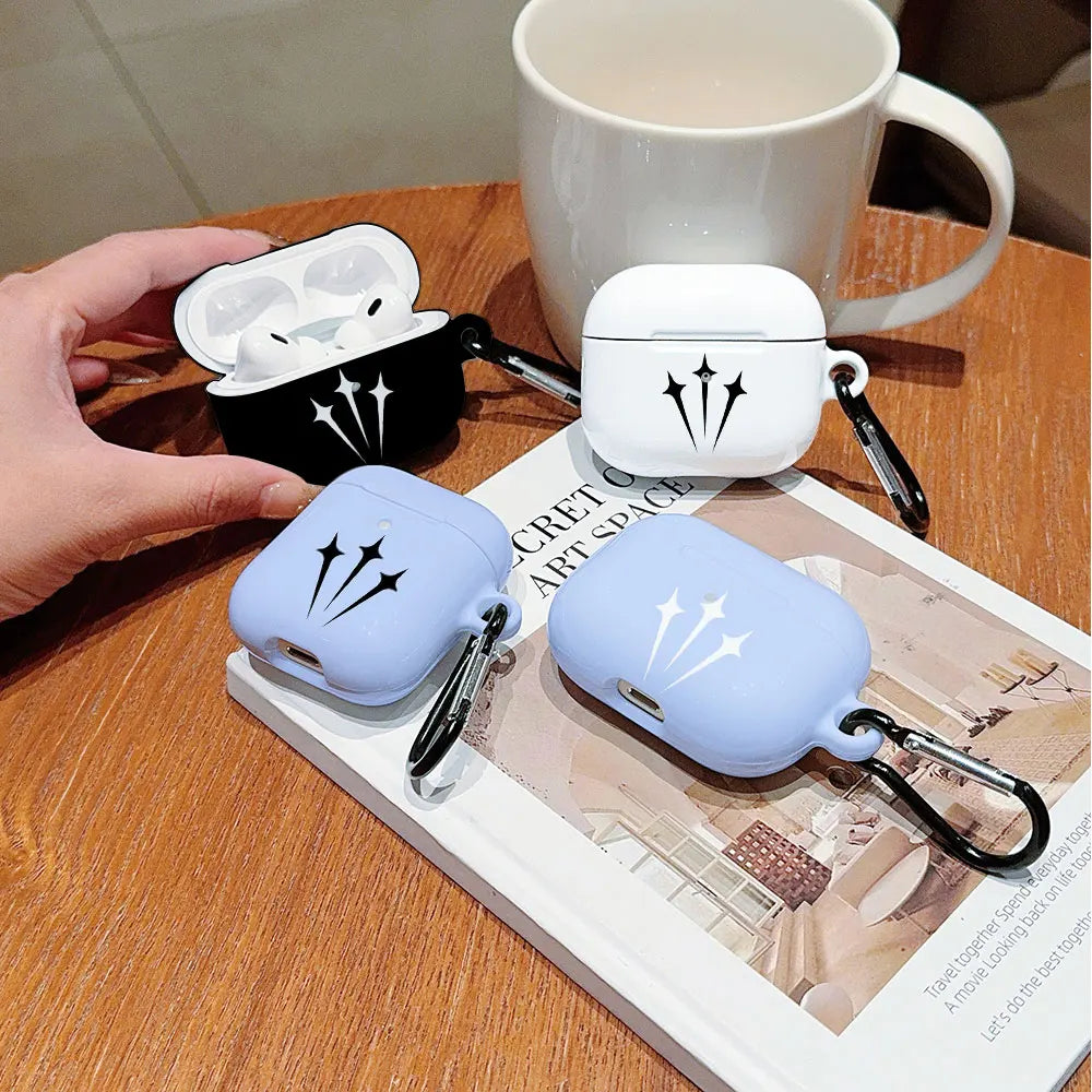 Black, white, and blue silicone AirPods Pro cases with star print designs, each featuring a metal carabiner clip.