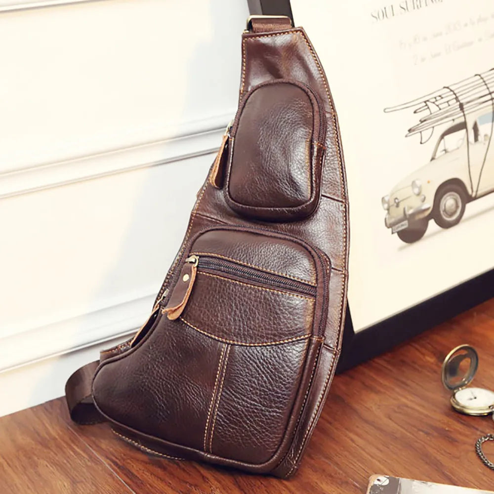 Brown leather crossbody sling bag with two zipped front pockets and adjustable shoulder strap.
