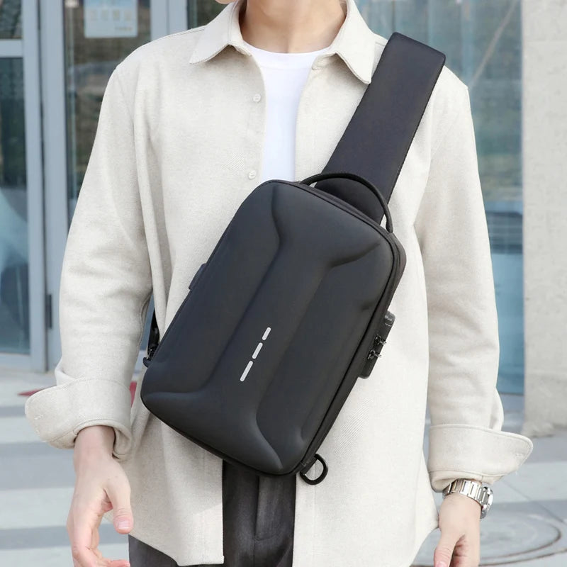 A man wearing a sleek, black anti-theft crossbody bag featuring a hardshell design and integrated USB charging port.