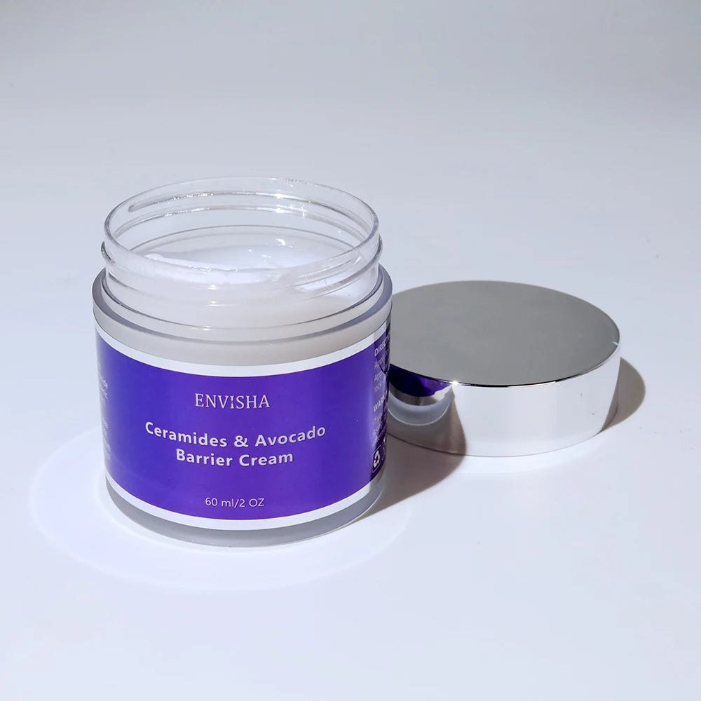 Open jar of Ceramides & Avocado barrier cream with a purple label and reflective silver lid on a white background.