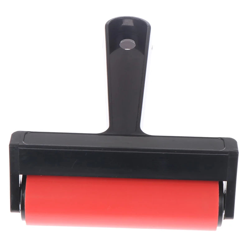 Craft roller with a bright red rubber barrel and a black plastic handle featuring a hanging hole.