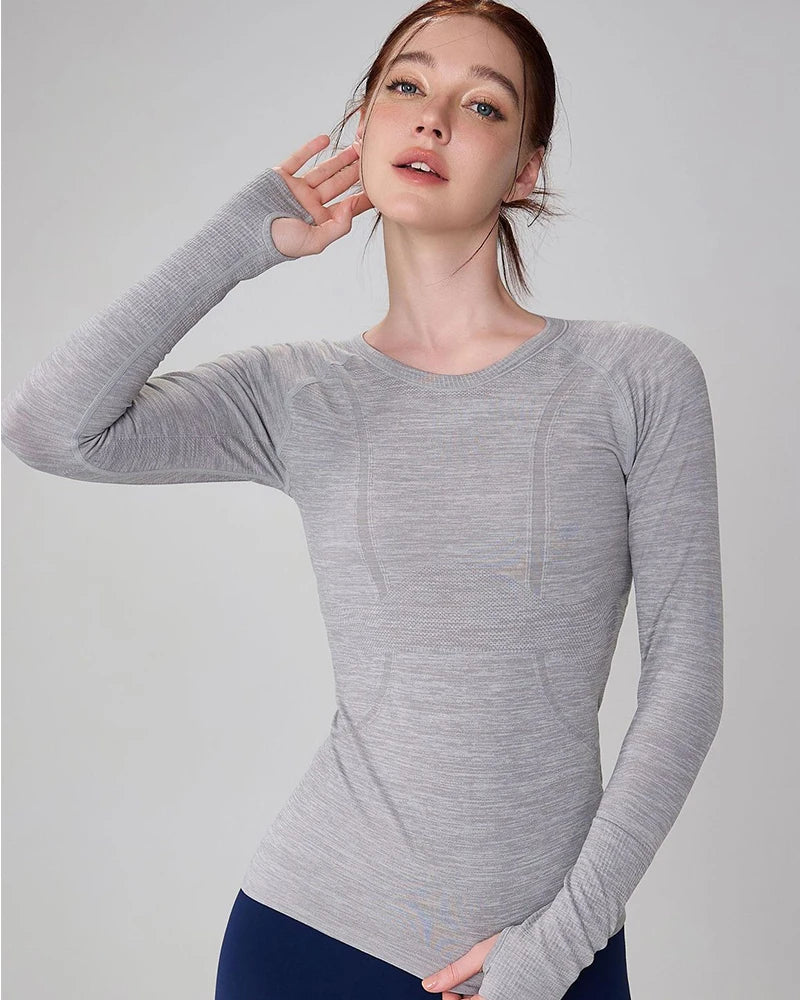 Women's long-sleeve grey marl seamless gym top with ribbed detailing and thumbhole cuffs.