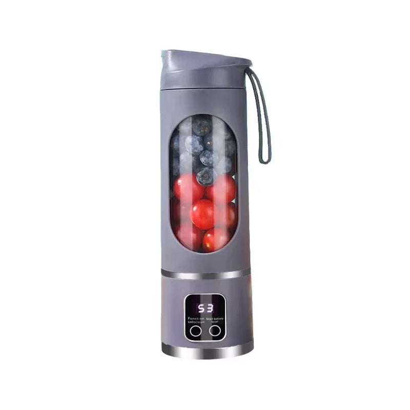 Grey portable blender bottle with digital display, containing blueberries and cherry tomatoes. Includes a carrying strap.
