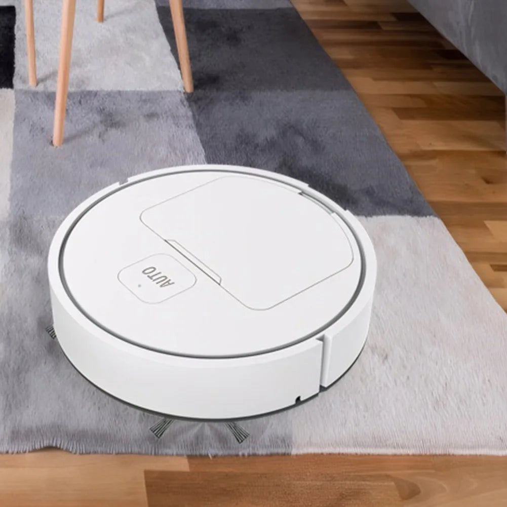 A white robotic vacuum cleaner with a rectangular "AUTO" button on top on a grey carpet.